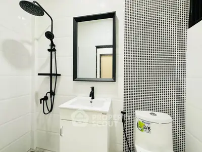 Modern bathroom with sleek black fixtures and stylish mosaic tile accent wall.