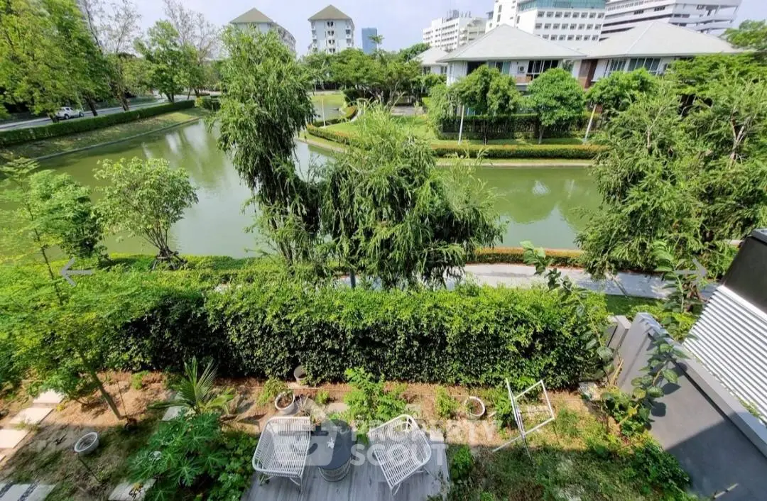 Stunning garden view from balcony overlooking serene water and lush greenery.