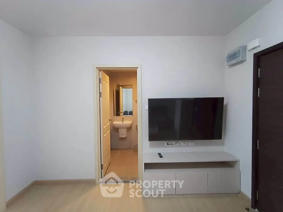 Modern living room with TV and bathroom access, sleek design