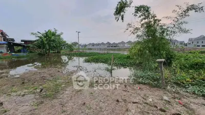 Scenic view of residential area with lush greenery and water body, perfect for tranquil living.