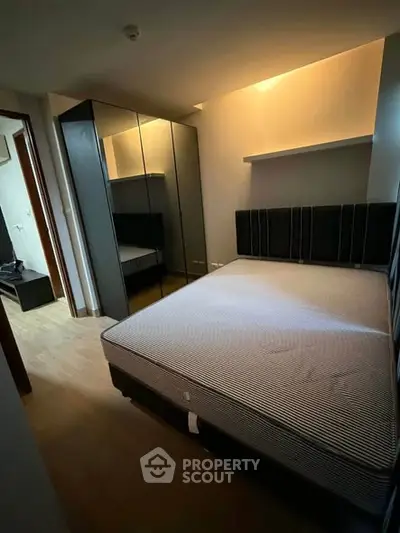 Cozy bedroom with modern mirrored wardrobe and ambient lighting