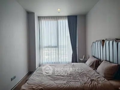 Modern bedroom with large window and stylish bed in high-rise apartment
