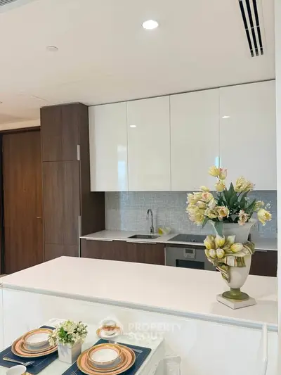 Modern kitchen with sleek cabinetry and elegant dining setup in a stylish apartment.