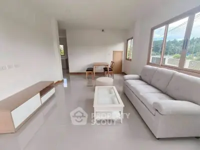 Spacious living room with modern furniture and large windows offering natural light.