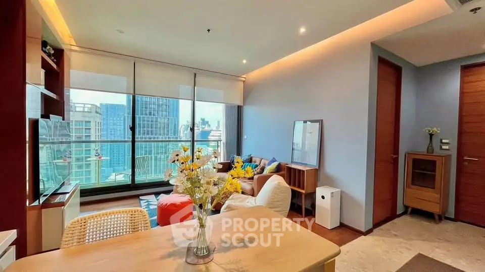Modern living room with city view, featuring stylish furniture and large windows for natural light.