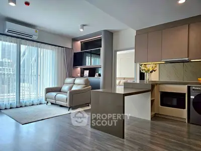 Modern open-plan living room with sleek kitchen and natural light