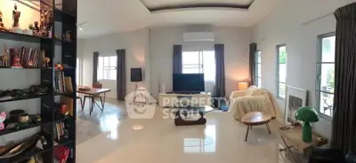 Spacious living room with modern decor and abundant natural light