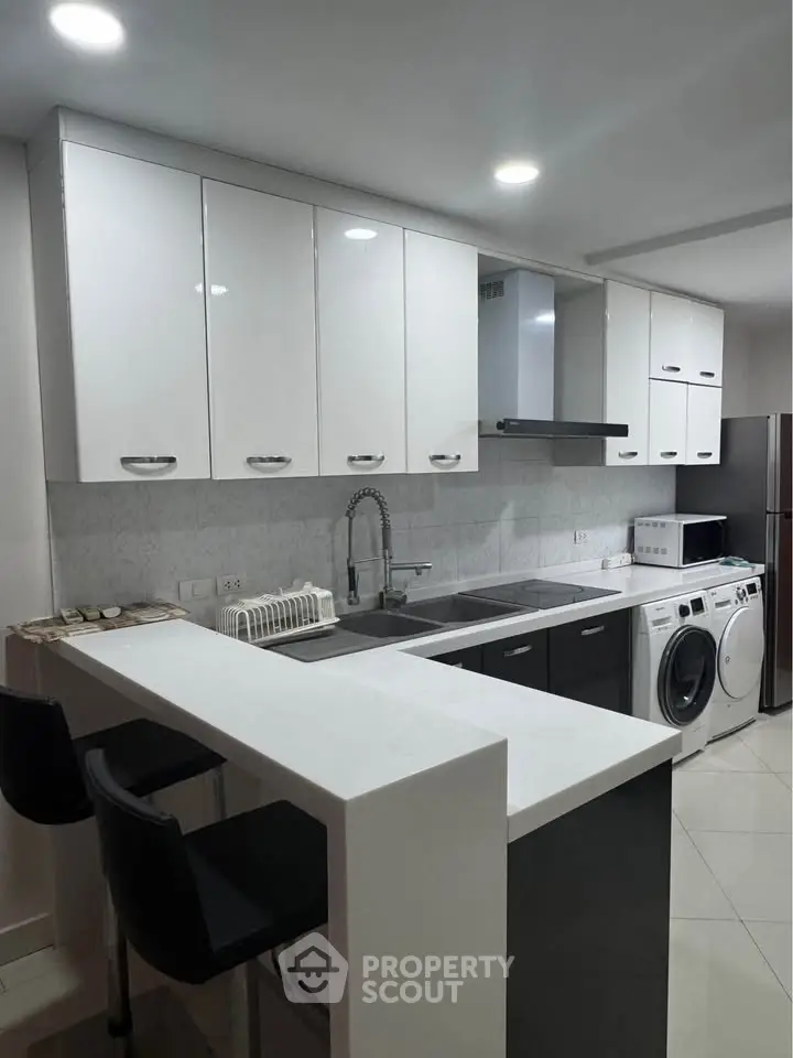 Modern kitchen with sleek cabinetry, breakfast bar, and built-in appliances for stylish living.