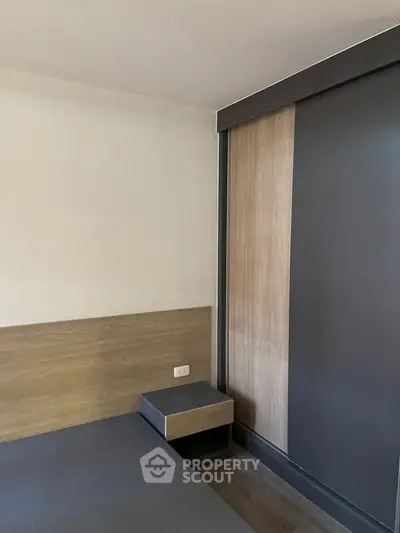 Modern bedroom with sleek wooden paneling and built-in storage