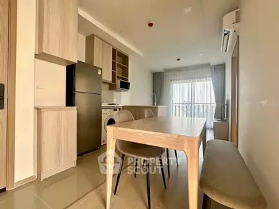 Modern kitchen and dining area with natural light and sleek appliances.
