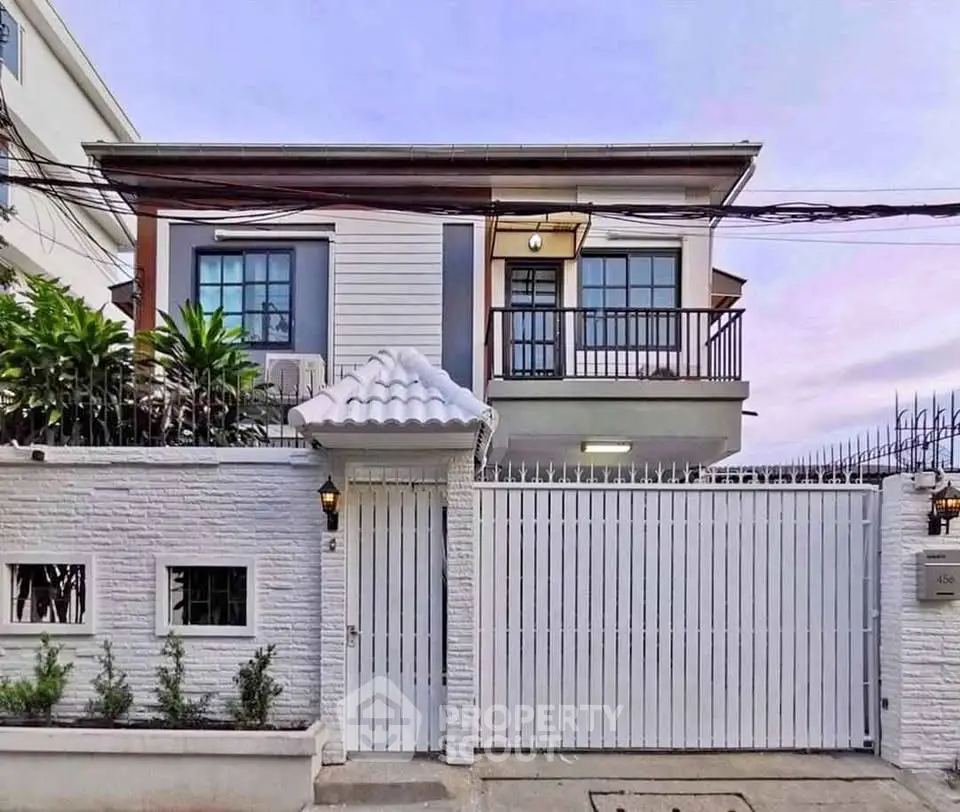 Charming two-story house with modern facade and gated entrance