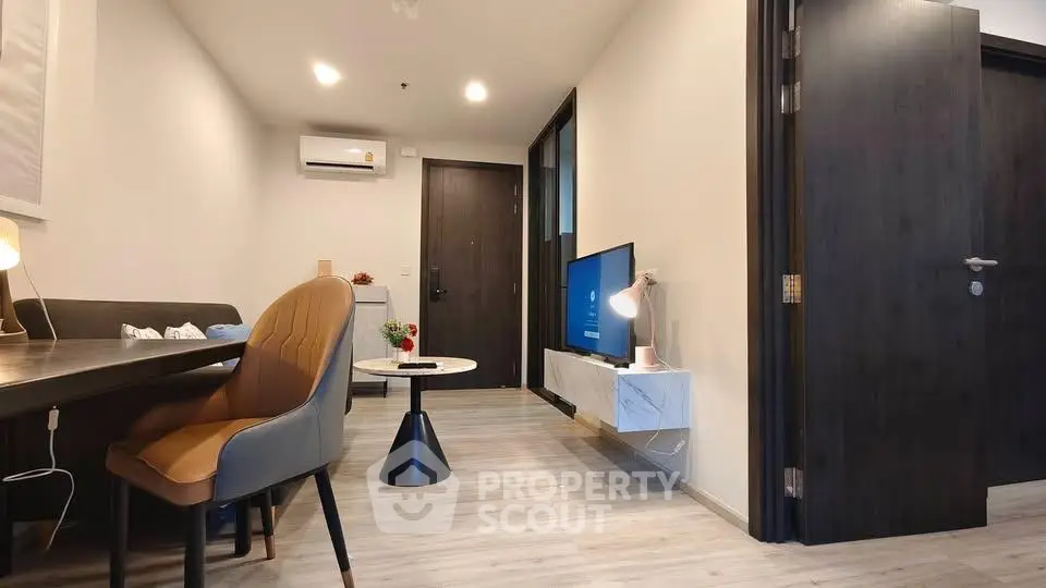Modern living room with sleek furniture and wall-mounted TV in a stylish apartment.
