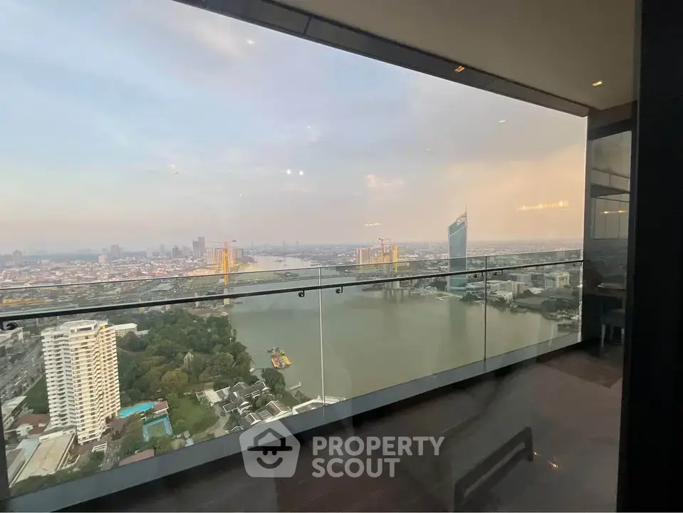 Stunning high-rise balcony view overlooking river and city skyline, perfect for urban living.