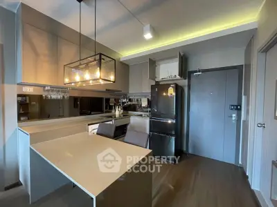 Modern kitchen with sleek design, featuring a stylish light fixture and contemporary appliances.