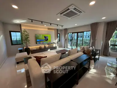 Spacious modern living room with large windows and stylish decor.