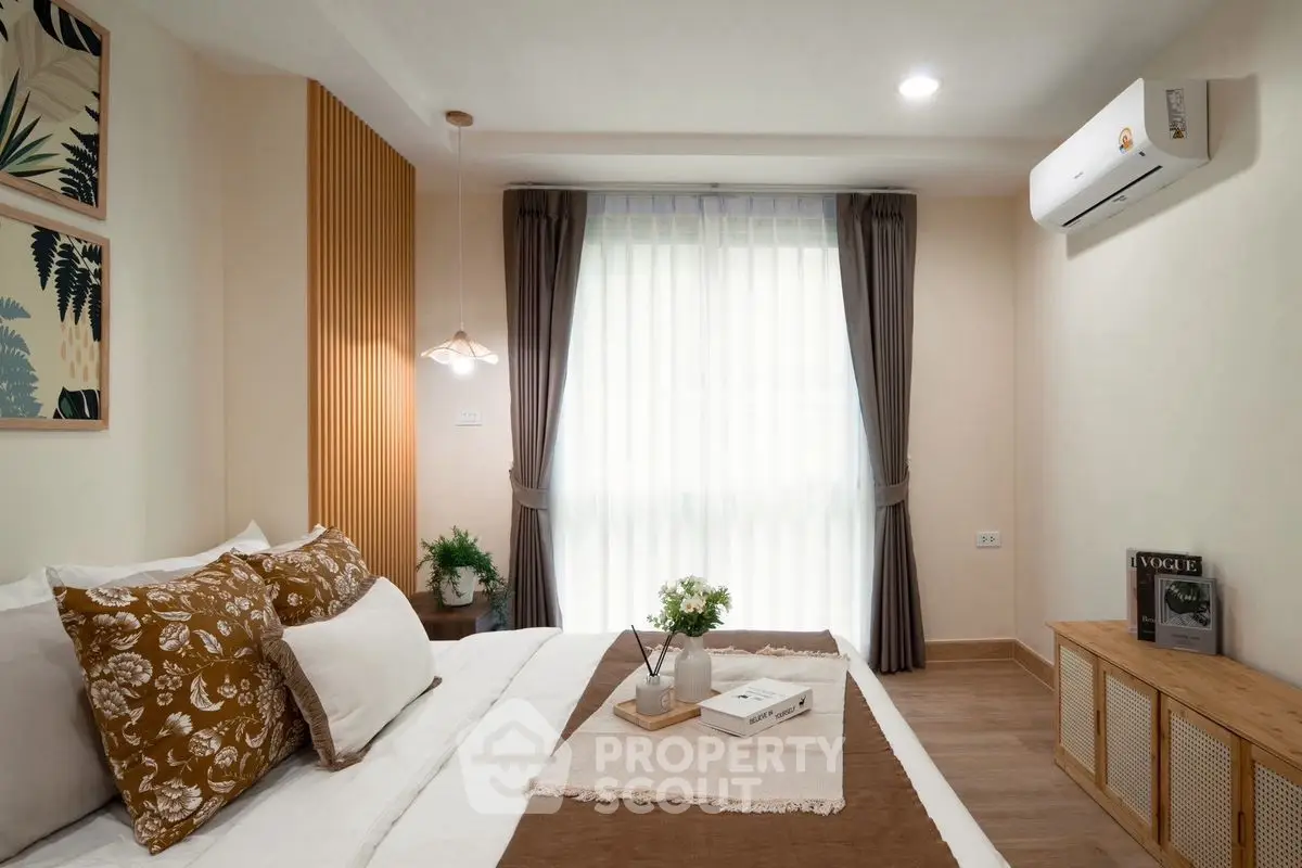 Cozy bedroom with modern decor, featuring a comfortable bed, stylish lighting, and natural light from large windows.