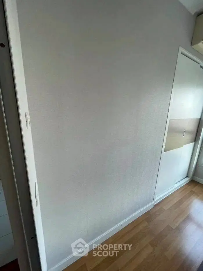 Minimalist room with wooden flooring and sliding closet doors