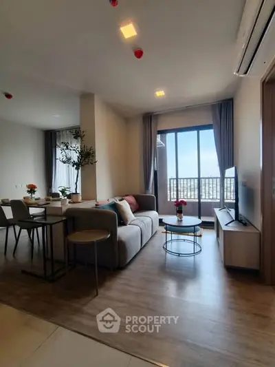 Modern living room with stylish decor and large window offering city view