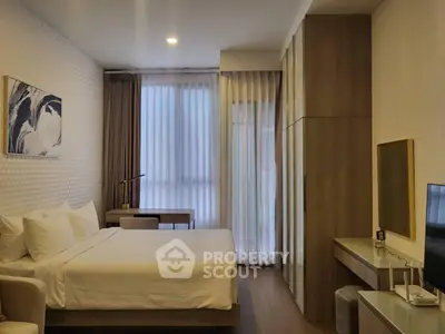 Modern bedroom with elegant decor and natural light, featuring a comfortable bed and stylish furnishings.