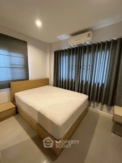 Modern bedroom with sleek design and natural light, featuring a comfortable bed and stylish curtains.