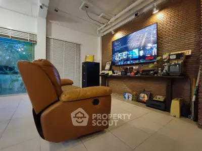 Stylish living room with leather recliner and large TV, perfect for entertainment.