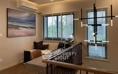 Modern living room with stylish lighting and cozy seating area, featuring large windows and elegant decor.