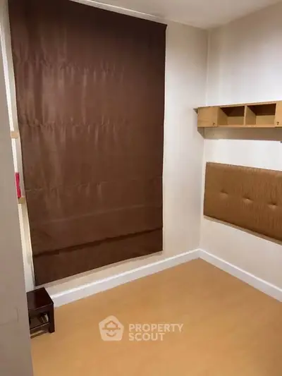 Cozy small room with brown curtain and wooden shelves, ideal for a compact living space.