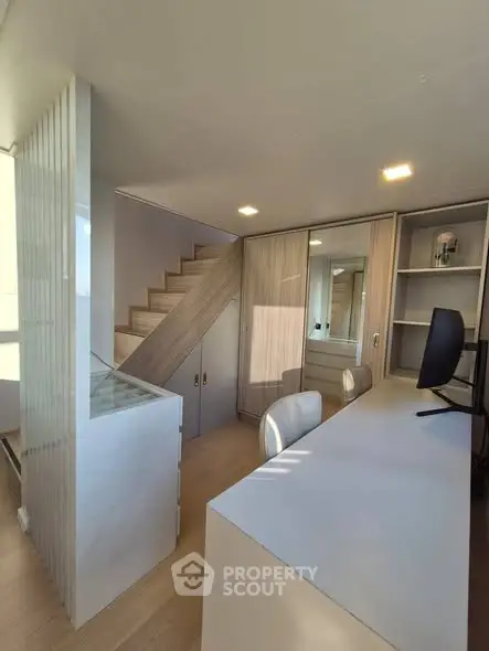 Modern study area with sleek desk and staircase in stylish home