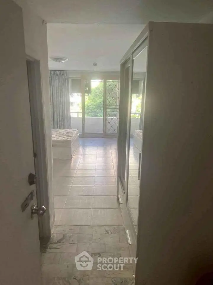 Spacious bedroom with large windows and natural light, featuring a comfortable bed and modern decor.