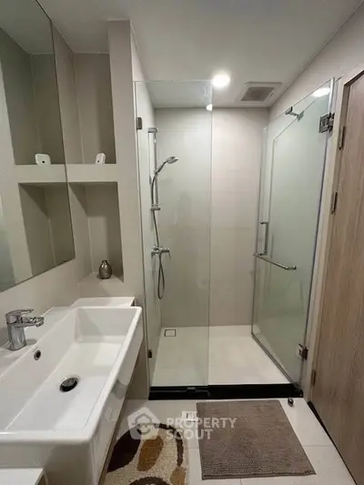 Modern bathroom with glass shower enclosure and sleek sink design