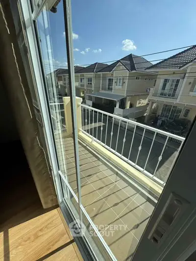 Charming balcony view of modern suburban homes with clear blue skies, perfect for serene living.