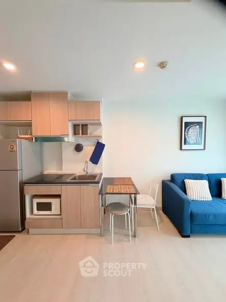 Modern open-layout kitchen and living room with stylish decor and cozy seating area.