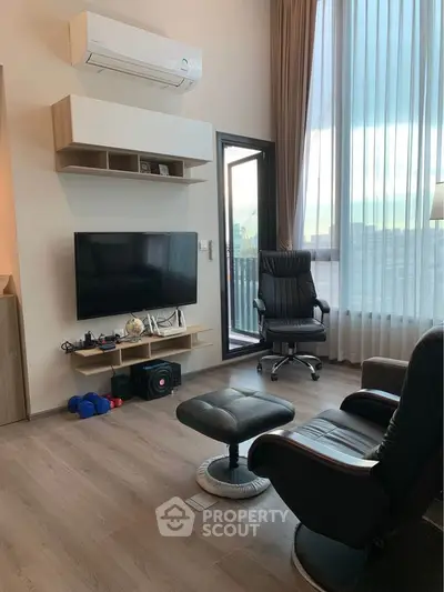 Modern living room with sleek furniture and large window offering city view