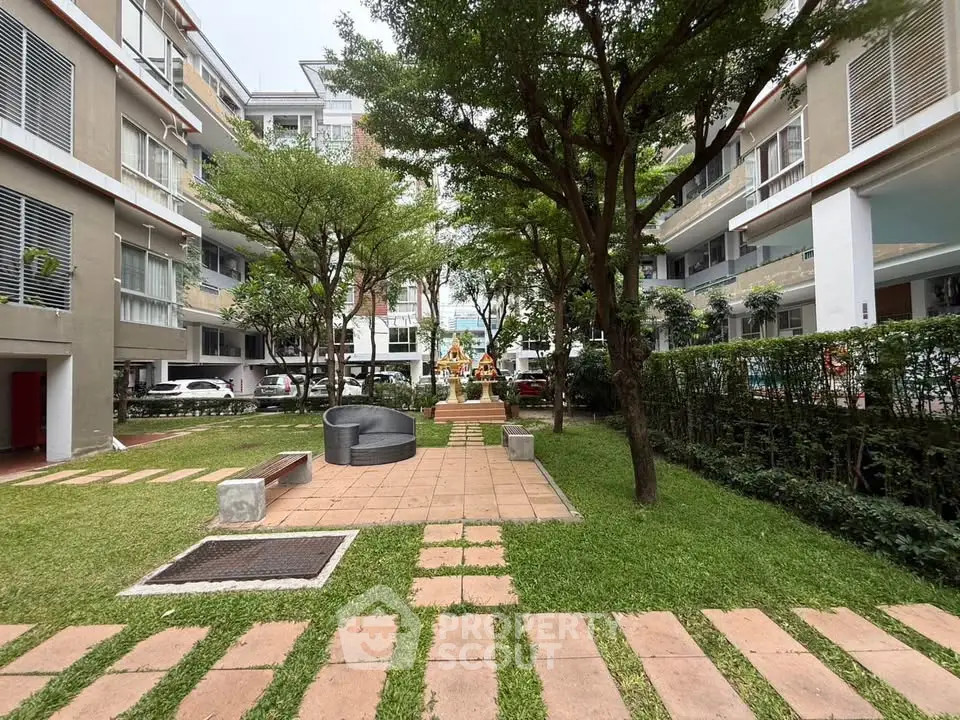 Charming residential courtyard with lush greenery and modern architecture.