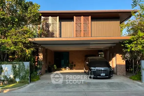 Modern two-story house with carport and lush greenery, perfect for family living.