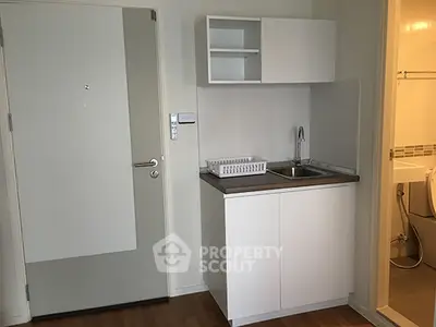 Compact studio apartment with kitchenette and bathroom, ideal for urban living.