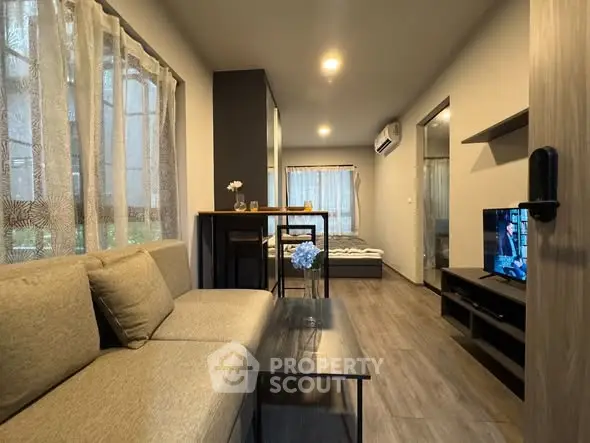 Modern living room with cozy seating and open layout in stylish apartment.