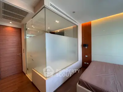 Modern bedroom with unique glass partition and wooden accents