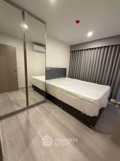 Modern bedroom with mirrored wardrobe and sleek flooring