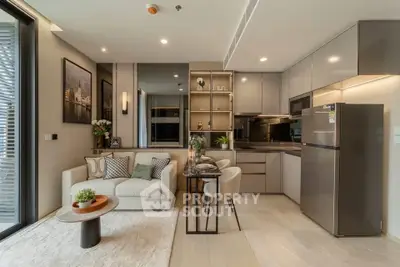 Modern open-layout kitchen and living room with sleek design and cozy ambiance.