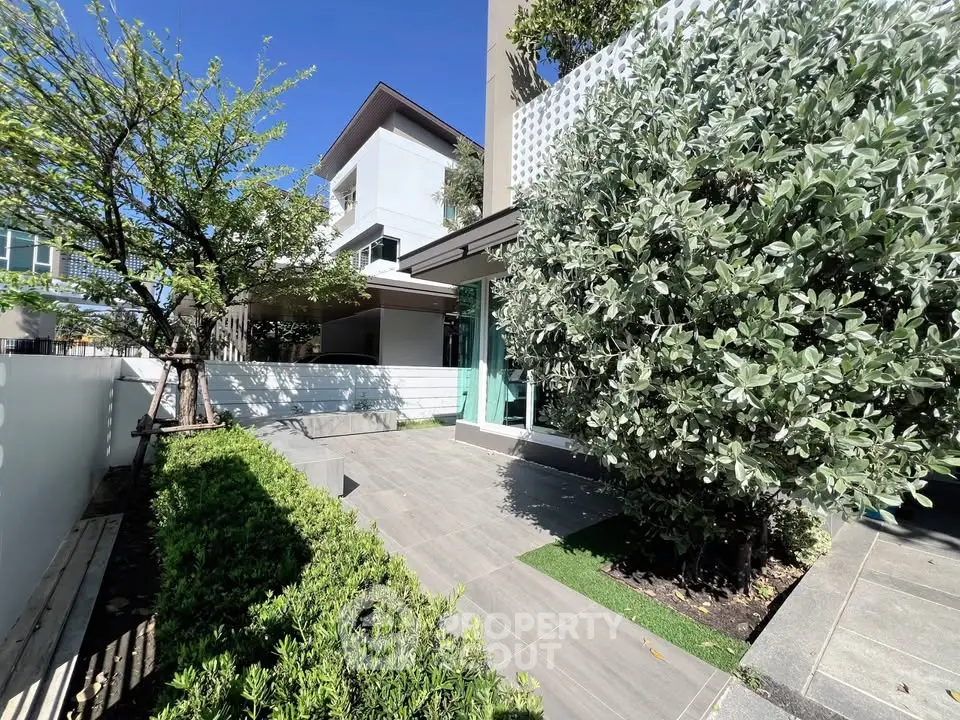 Modern home exterior with lush greenery and sleek design