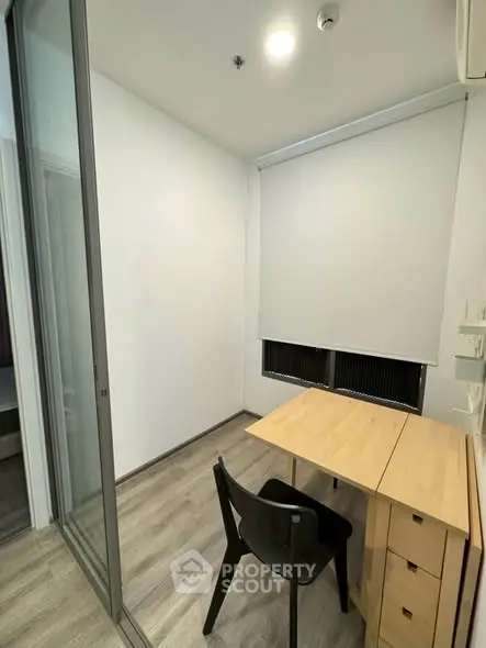 Modern study room with sleek wooden desk and chair, featuring minimalist design and ample natural light.