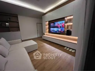 Modern living room with sleek entertainment center and cozy seating area.