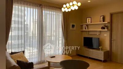 Modern living room with large windows, stylish furniture, and elegant lighting in a high-rise apartment.