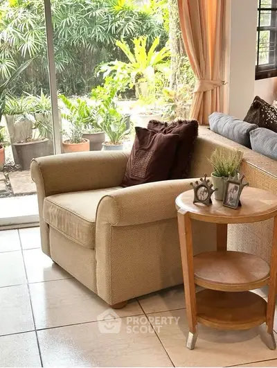 Cozy living room with armchair and garden view, perfect for relaxation.