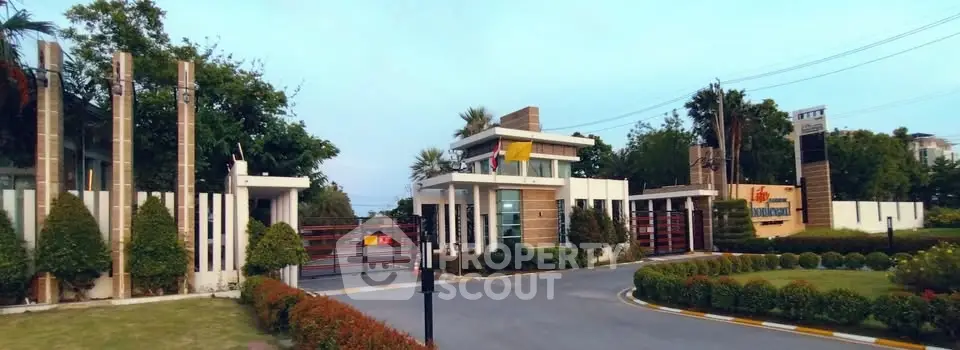 Luxurious gated community entrance with modern architecture and lush landscaping.