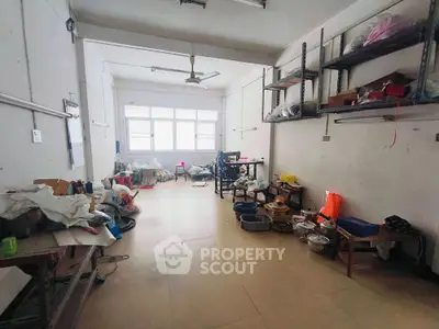 Spacious and versatile storage area with ample shelving, high ceilings, and large windows allowing for natural light, perfect for organizing belongings or converting into a creative workspace.