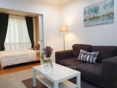 Cozy living room with modern decor and adjacent bedroom view