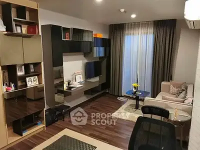 Modern living room with stylish decor and wooden flooring, featuring a cozy seating area and elegant shelving.