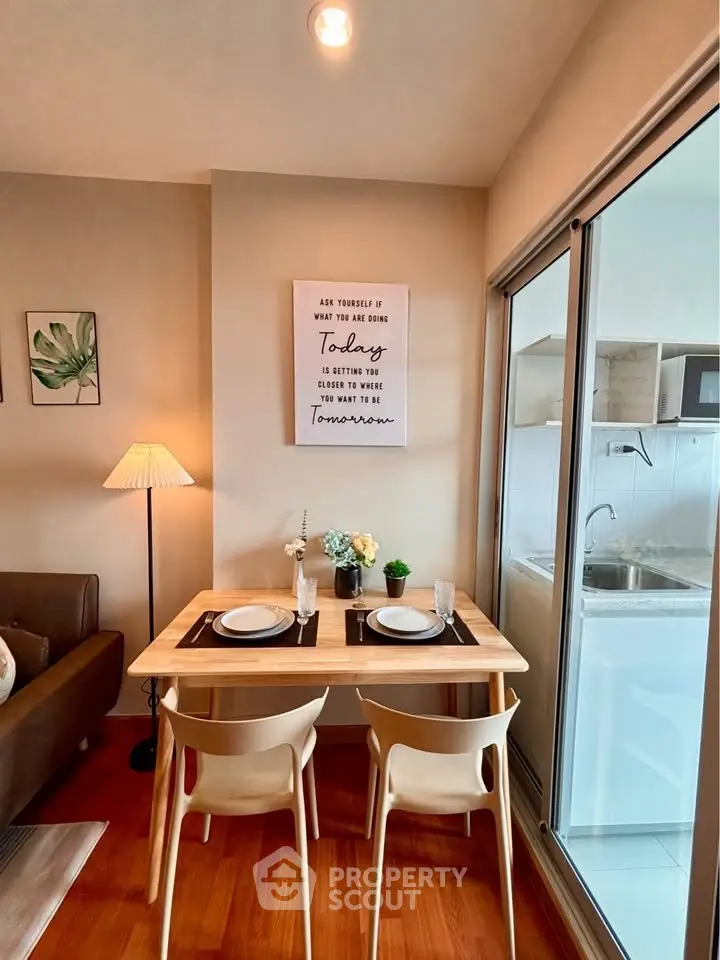Cozy dining area with modern decor and adjacent kitchen in stylish apartment.